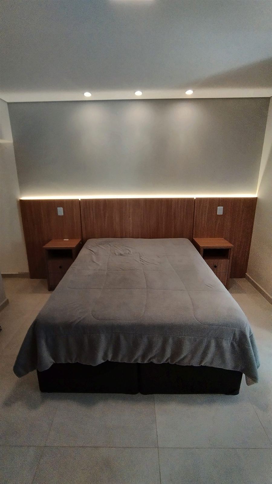 Quarto com cabeceira planejada e iluminação embutida