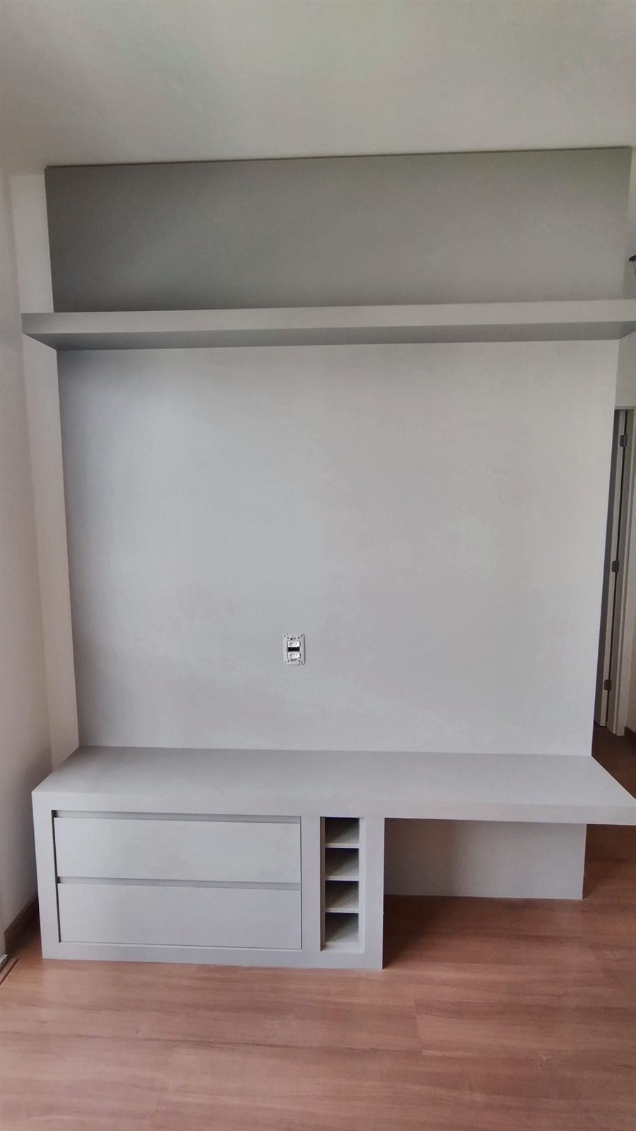 Painel de TV planejado com bancada e nichos em sala de estar